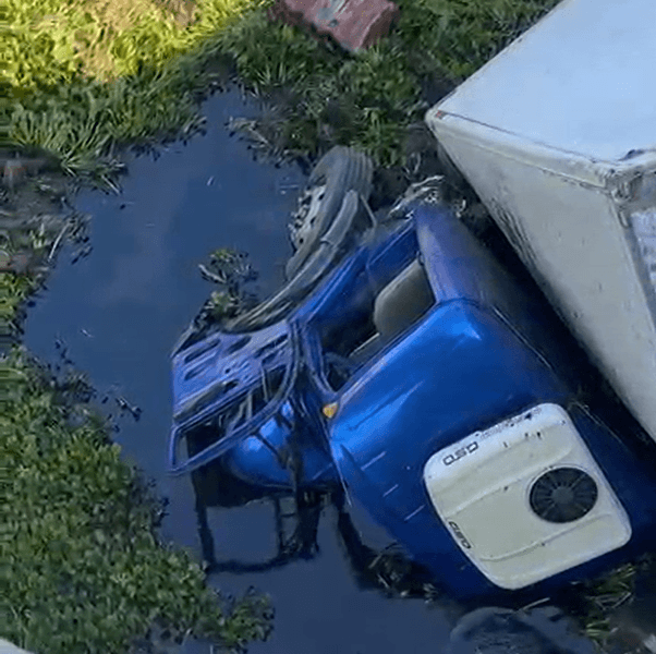 Caminhão cai de ribanceira após desviar de ônibus escolar durante travessia de ponte em Pilões